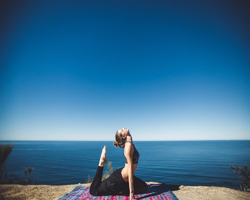 healthy woman doing a gentle yoga stretch outdoors